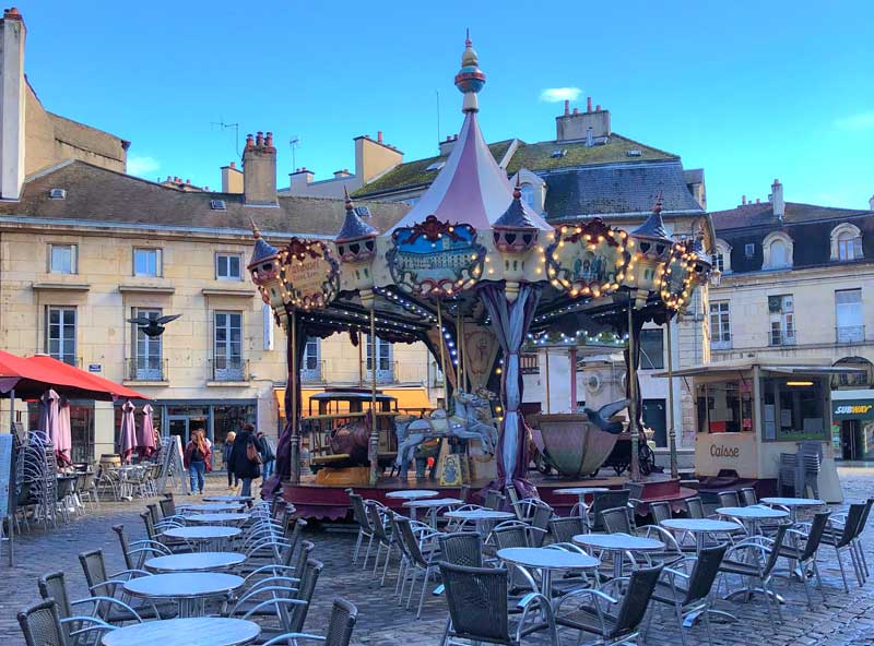Dijon en Bourgogne Place pavée avec un carrousel au centre, bordée de vieux bâtiments à Dijon, Bourgogne