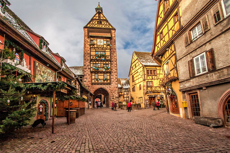 Riquewhir en hiver Photo: Lori Prosser Rue pavée bordée de maisons à colombages colorées, Riquewihr, Alsace