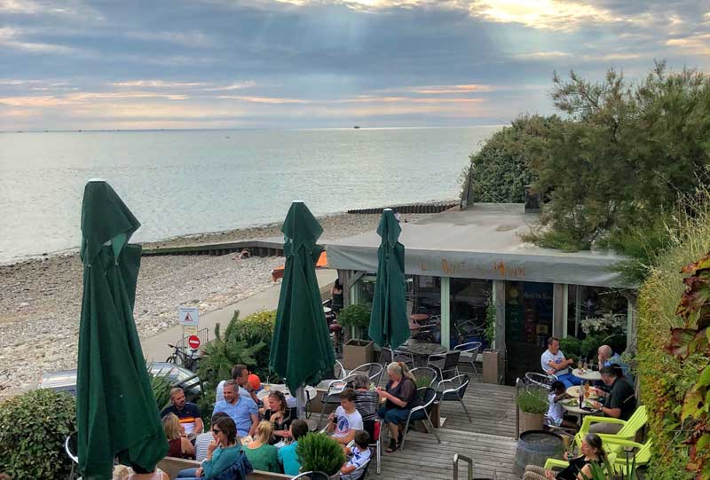 Café de plage au Havre par temps nuageux surplombant la vaste plage et la mer