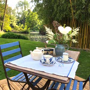 Table et chaises au bord d'un ruisseau dans les jardins flottants d'Amiens
