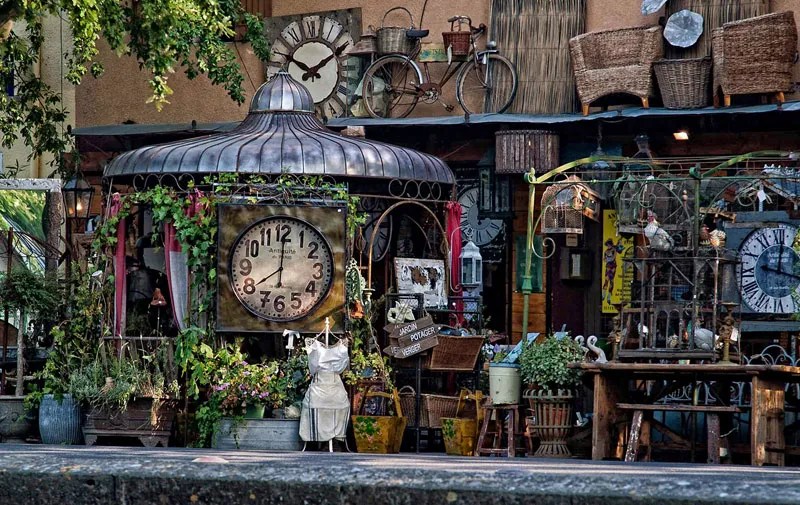 Antiquités empilées devant un magasin au bord de la Sorgue en Provence