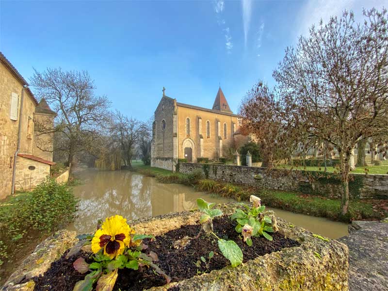 Vue depuis un petit pont sur la ville de Fources, Gers surplombant la rivière, une église sur ses rives