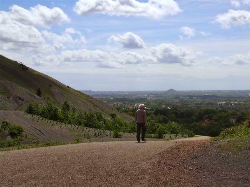 Un homme gravit un terril de charbon pour admirer la vue sur Lens.  nord de la France