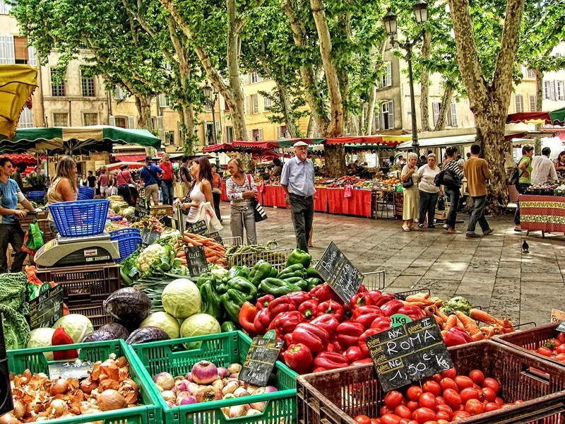Vue du marché d'Aix-en-Provence, étals remplis de fruits sous les platanes