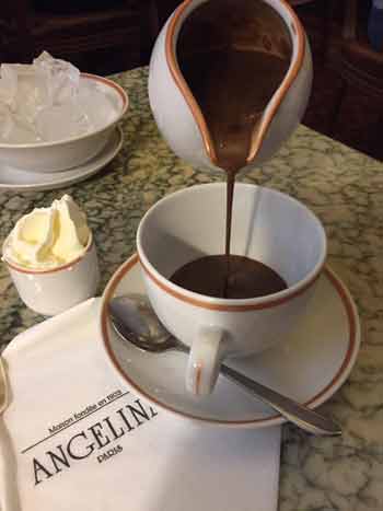 Chocolat chaud versé d'une carafe au salon de thé Angelina à Paris
