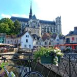 Amiens Cathedral looming over the old district of St Leu, flower filled pots along a cafe lined canal