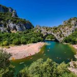 Canoes on the River Ardeche, clear blue green waters, a sunny day, surrounded by mountains