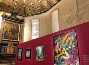 Inside an ancient church infirmary, ceiling covered in gilded paintings an altar at one end