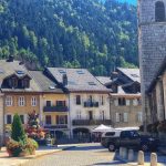Street view of Thones in the French Alps, traditional cafe and village church in the centre