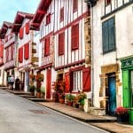 Pretty red and white half timbered houses in a narrow street, Ainhoa, Basque country