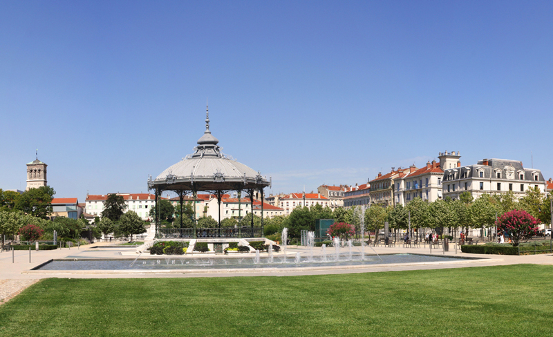 Une ville élégante Photo © Valence Romans Tourisme Élégant kiosque à musique à sommet pointu dans un parc verdoyant entouré de gracieuses maisons de style Belle Époque