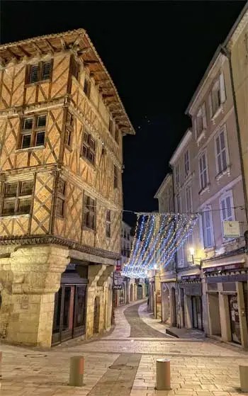 Rue bordée de maisons à colombages et de vieux bâtiments devenus commerces à Auch, Gers
