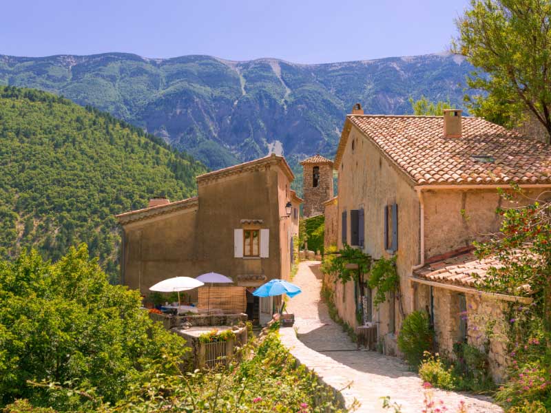 Une rue du village de Brantes avec une vue imprenable sur le Mont Ventoux en arrière-plan 