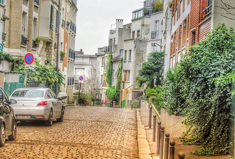 Une rue fleurie avec peu de circulation dans un village calme au centre du Paris animé, France