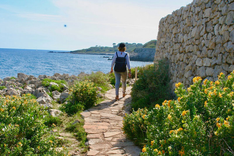 Femme marchant sur un sentier de randonnée au bord de la mer Méditerranée à Antibes, dans le sud de la France