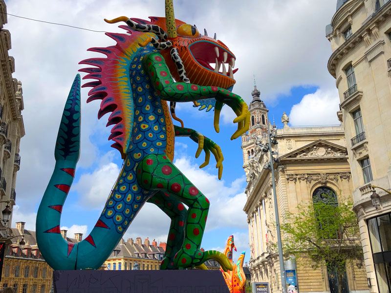 Des créatures géantes colorées sur des socles bordent les rues principales de Lille pendant le festival artistique Lille 3000