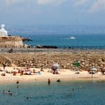 People sunbathing on a sandy beach on a sunny day in Antibes, southern France