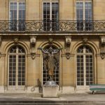 Stone facade of a grand mansion house in Paris with wrought iron balcony, now Musee Carnavalet