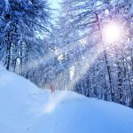 Ski slopes in Italy with single skier in red startling against the white background