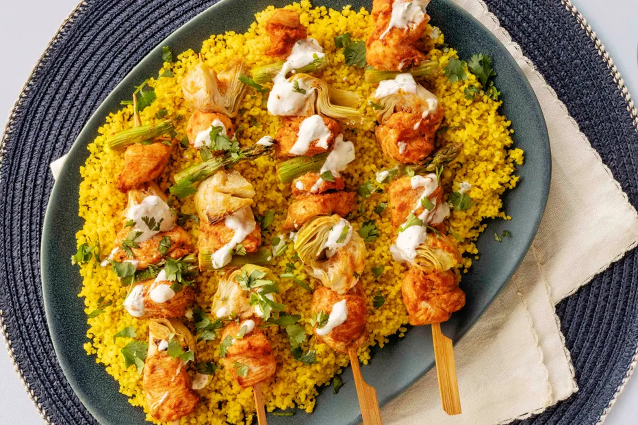 Espetadas de frango com alcachofras e molho servidas em couscous