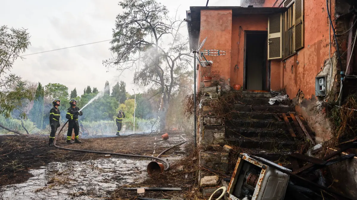 Feuerwehrleute und die örtliche Polizei sind am Ort eines Waldbrands nahe Roms im Einsatz. 